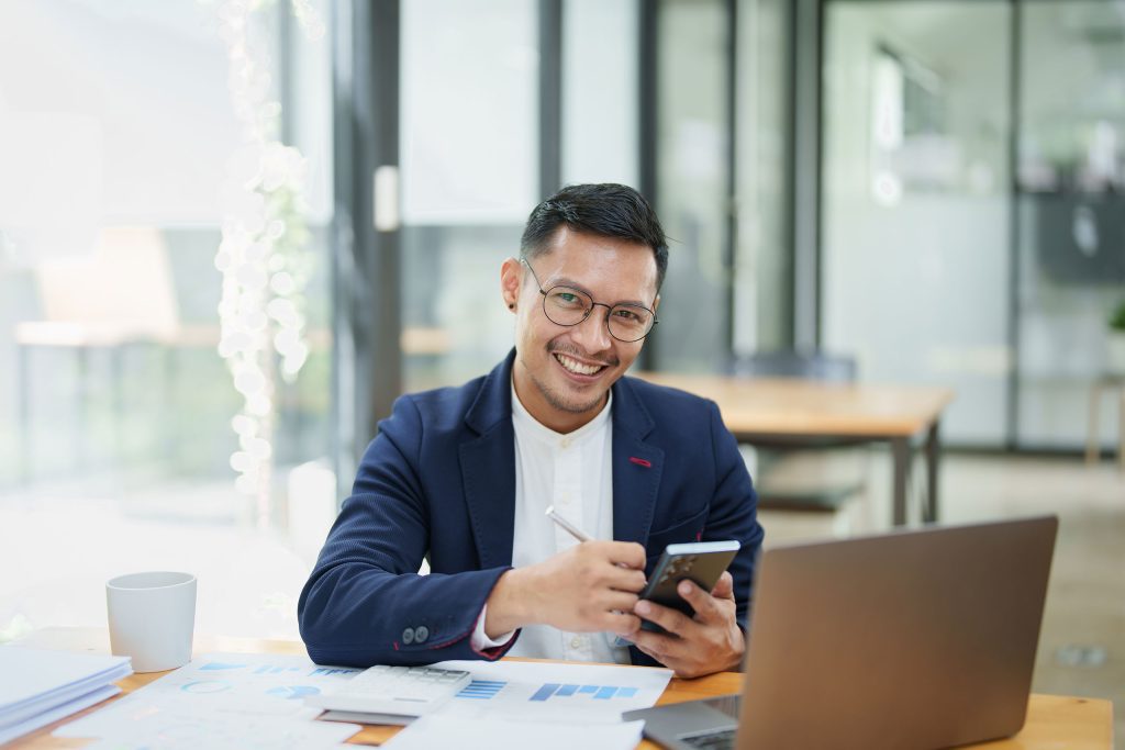Man working at his desk with a phone in hand