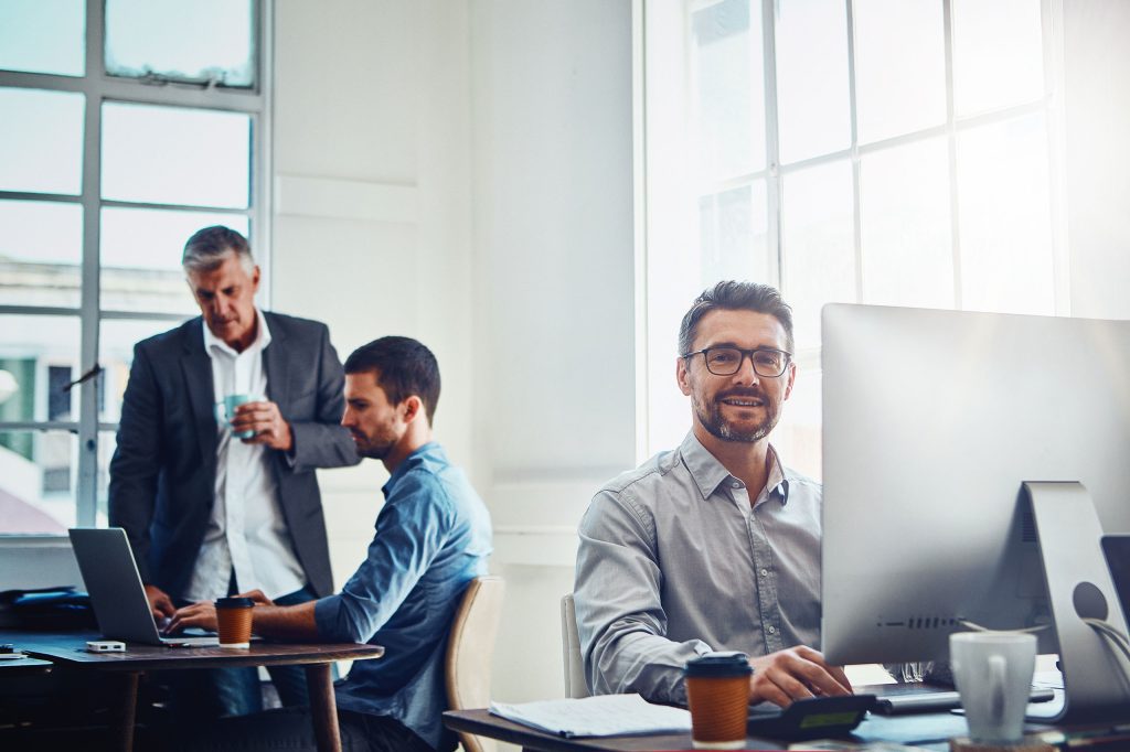 Men in office working at computers